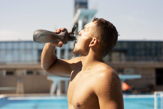 side-view-male-swimmer-drinking-water-stay-hydrated