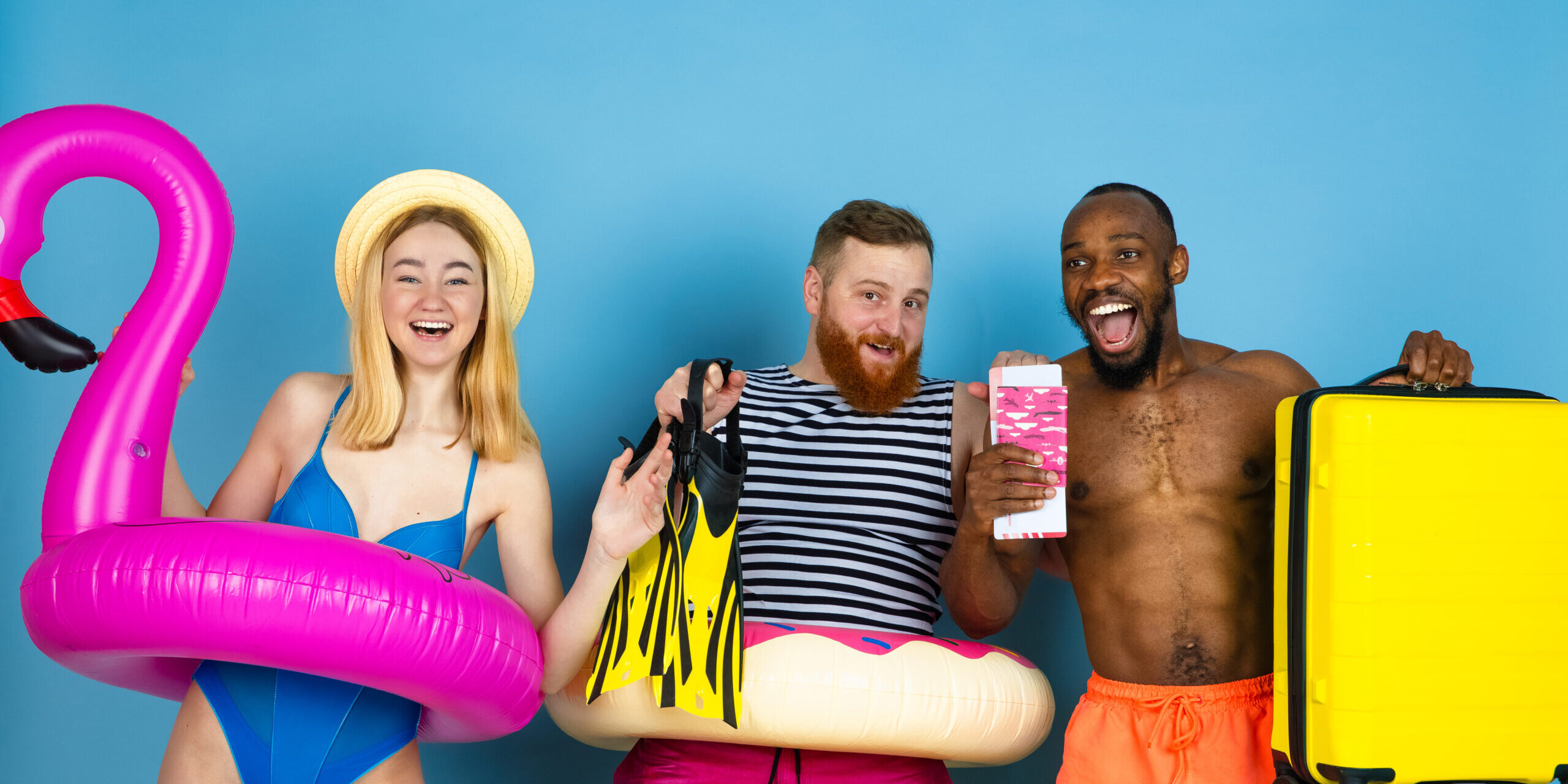 Happy young friends resting on blue studio background