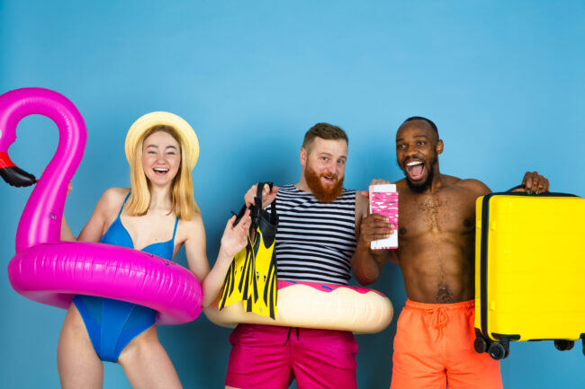 Happy young friends resting on blue studio background